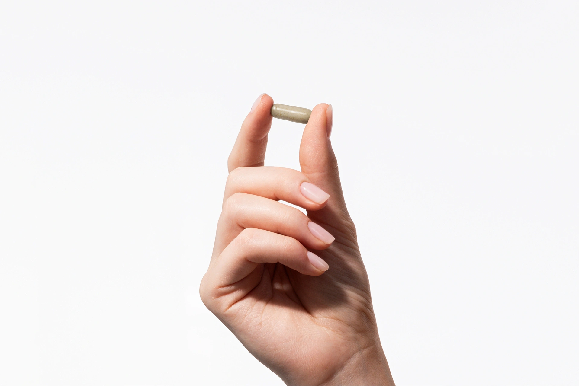 Format pratique de la gélule Quattrobiotic Formula en main sur fond d'intérieur esthétique